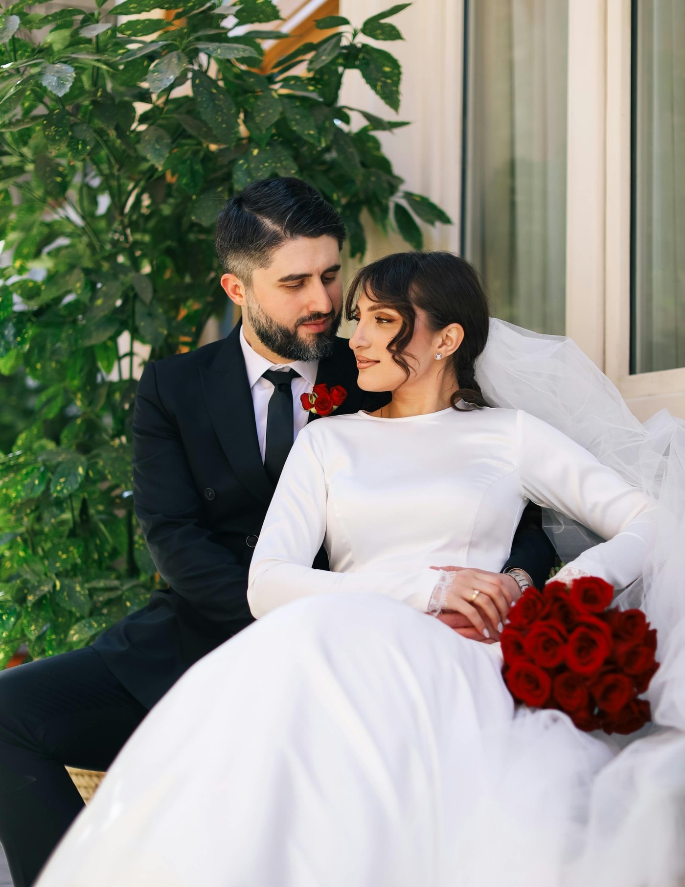 Bride and groom with red rose bouquet